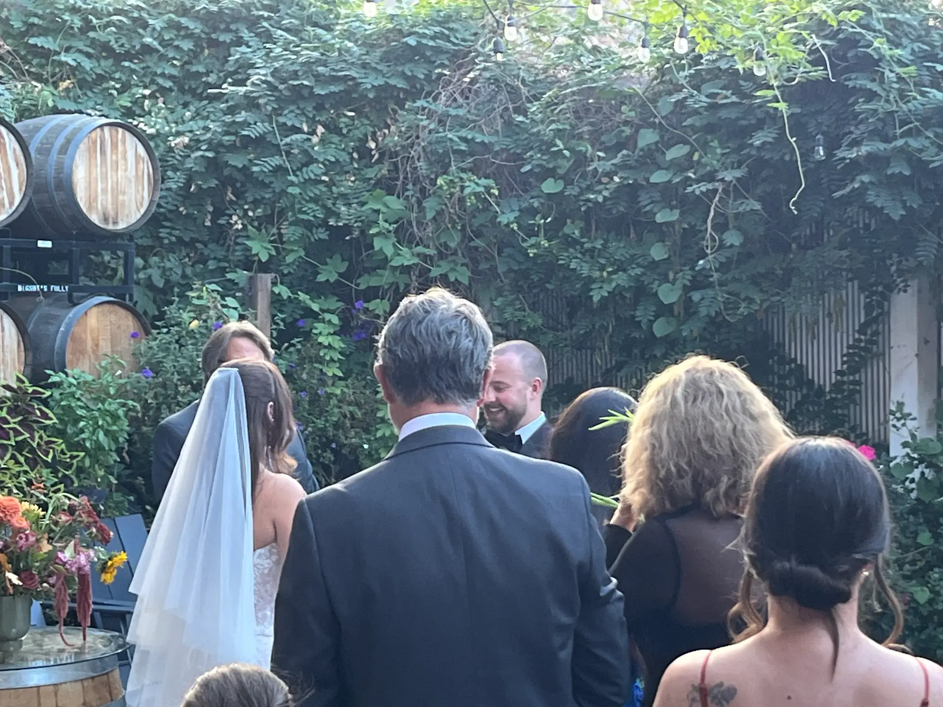 A bride and guests gathered on the ivy-covered courtyard patio