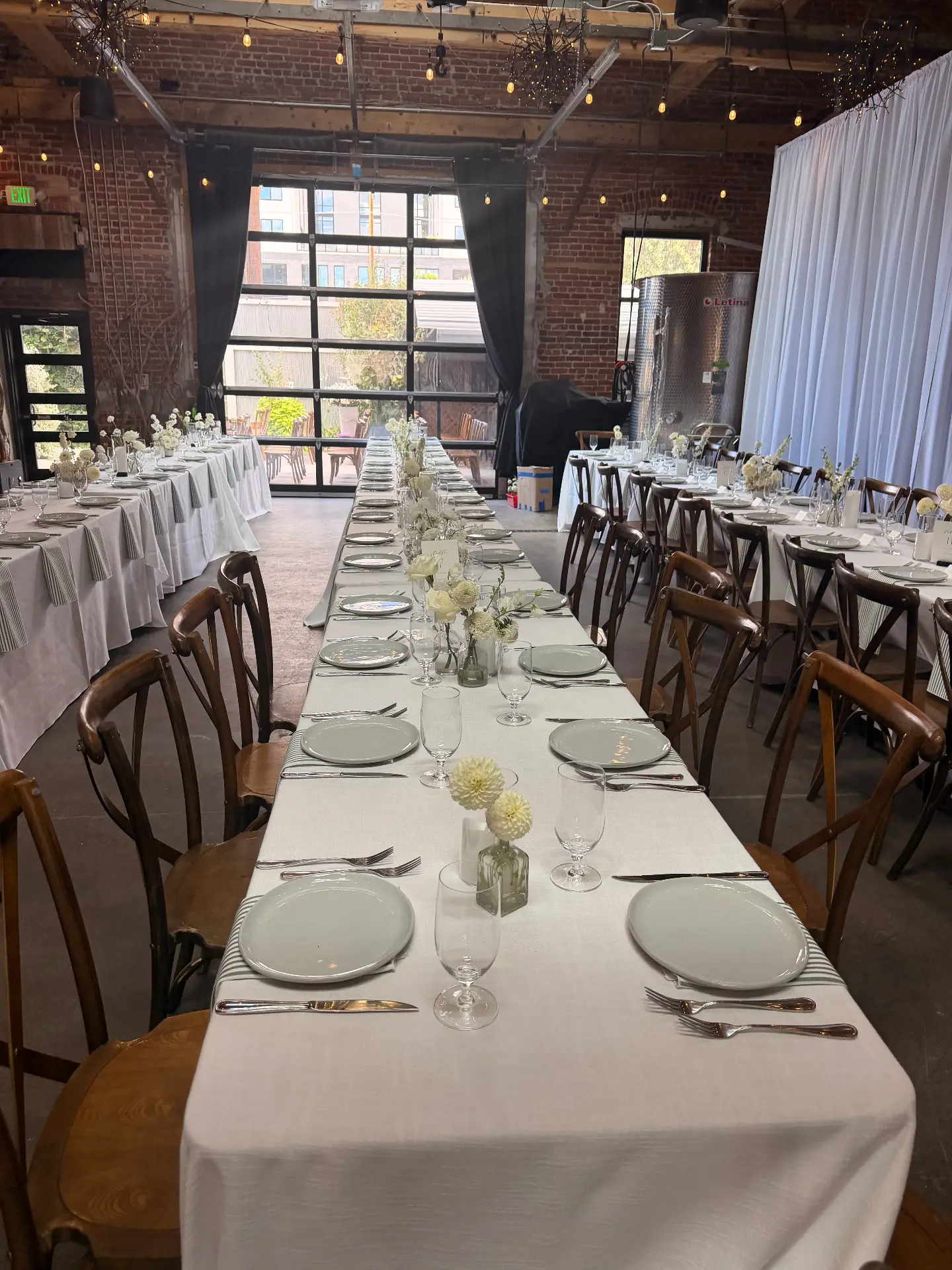 White-linen banquet tables set for a wedding dinner
