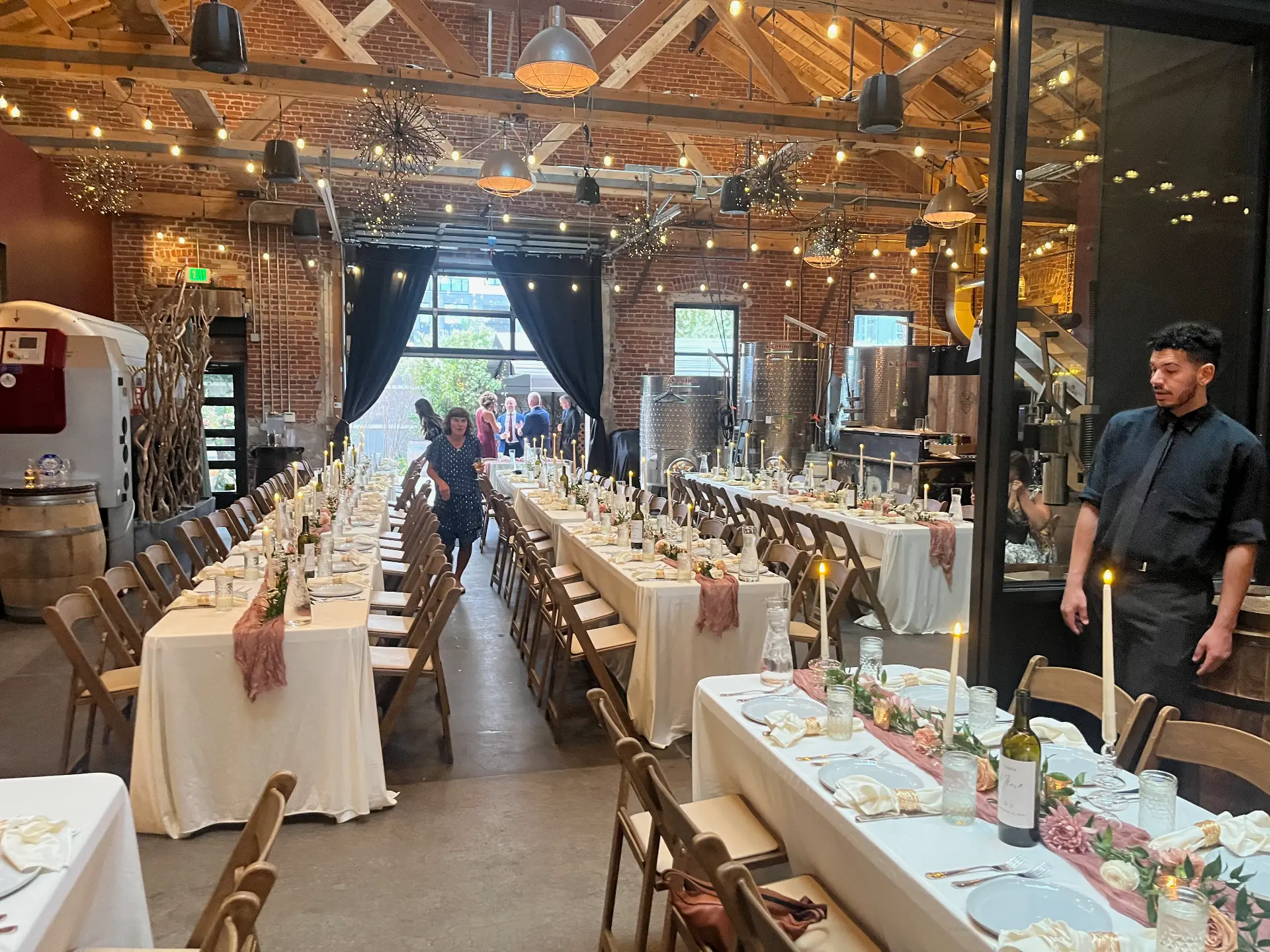 Long reception tables set with linens and florals in the hall