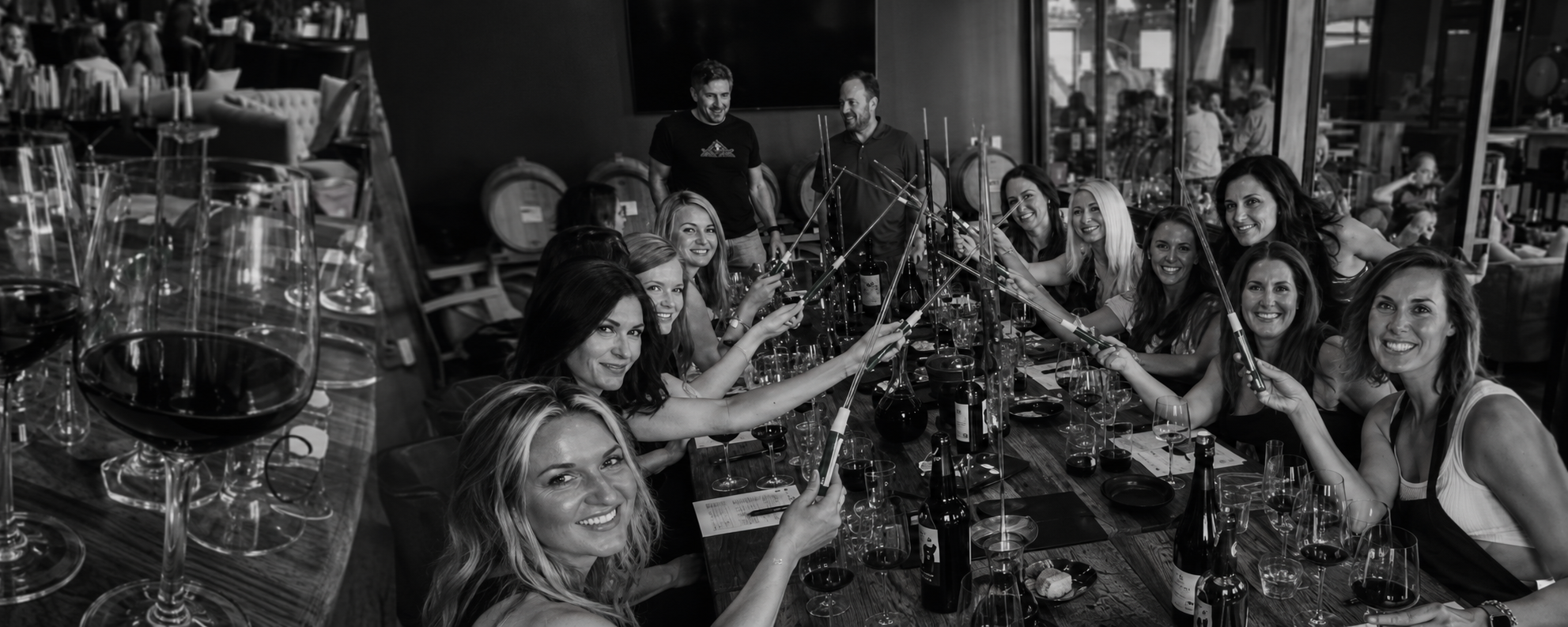 Guests blending wine with glass pipettes at a long table in the Bigsby's Folly barrel cellar